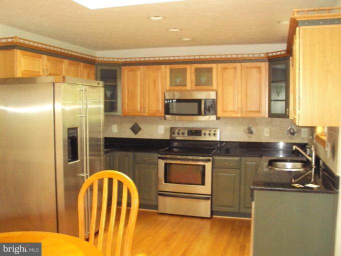 255 Mountain Top Road Front Royal, VA 22630 - Photo 7 of 30 a kitchen with stainless steel appliances granite countertop a stove a sink and a microwave