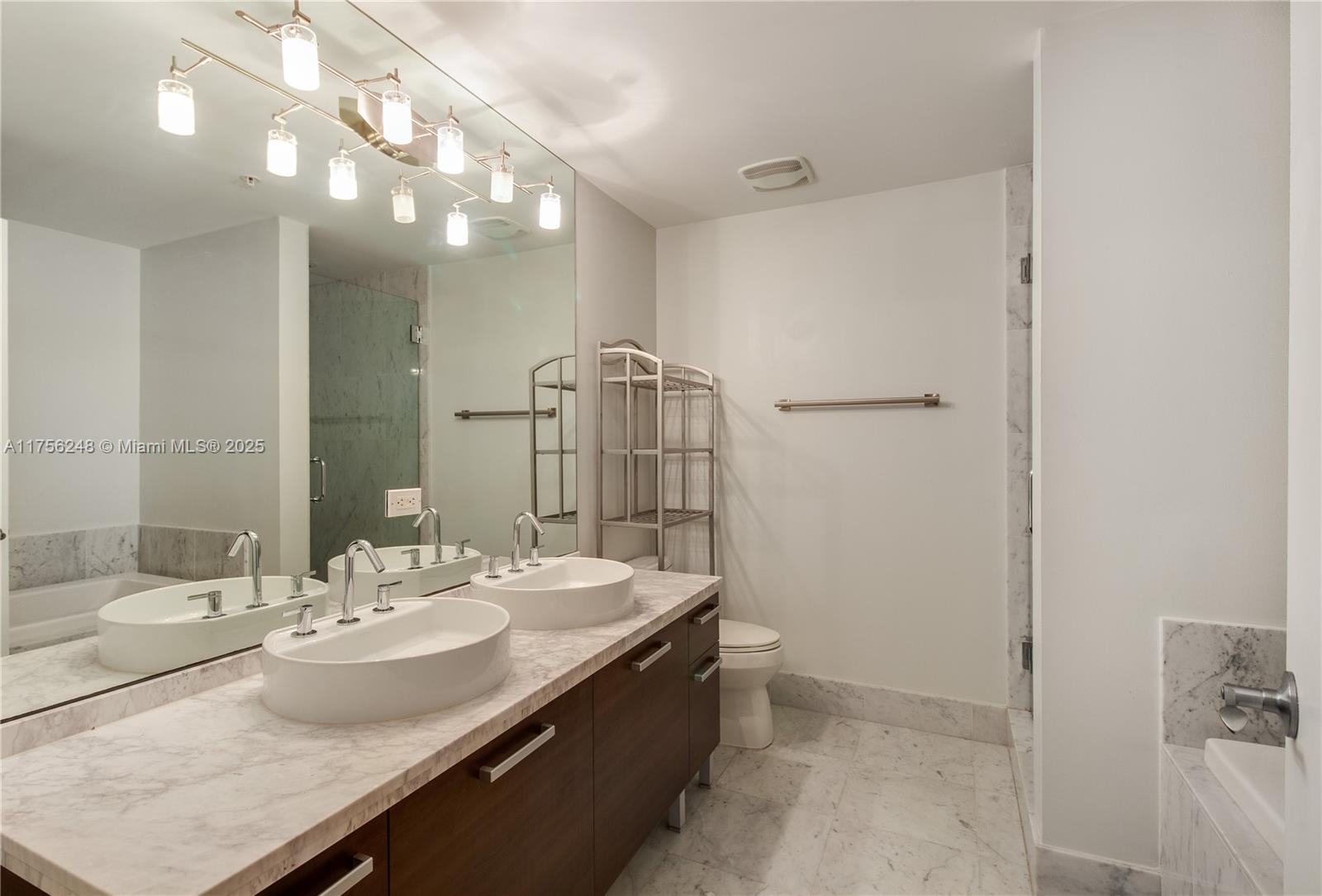 253 Northeast 2nd Street, Unit 3702 Miami, FL 33132 - Photo 21 of 25 a bathroom with a sink a toilet and shower