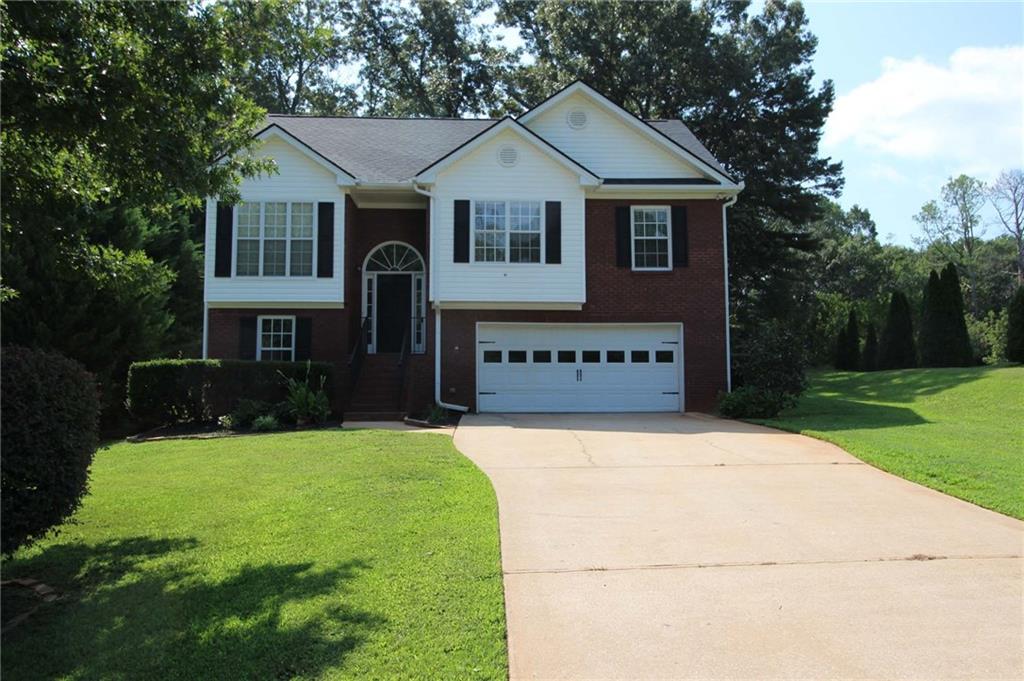 a front view of a house with a yard and garage