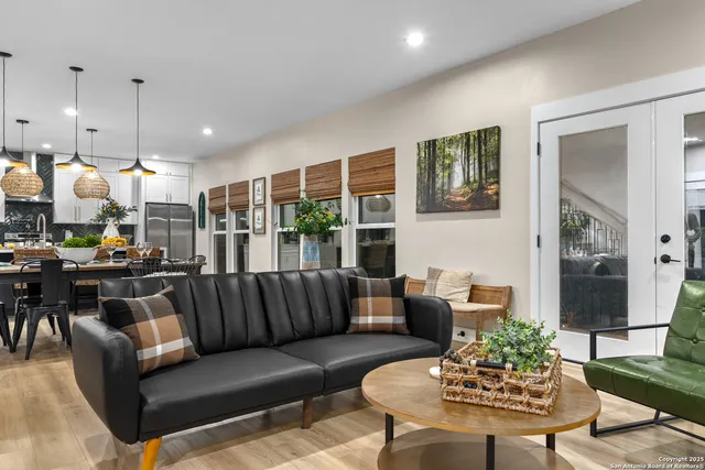 a living room with furniture kitchen view and a large window