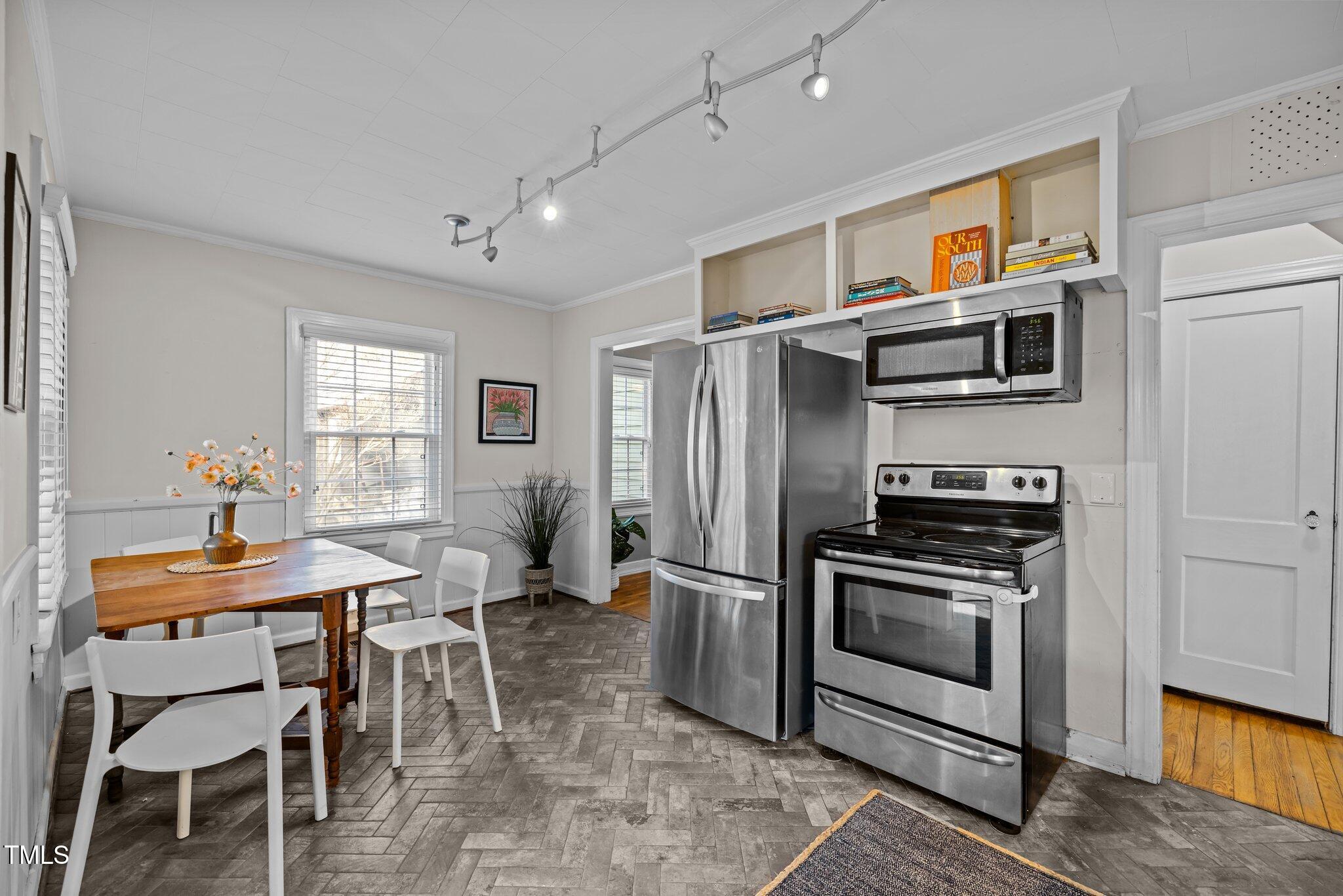 2511 State Street Durham, NC 27704 - Photo 13 of 45 a kitchen with stainless steel appliances kitchen island a table chairs in it and wooden floors