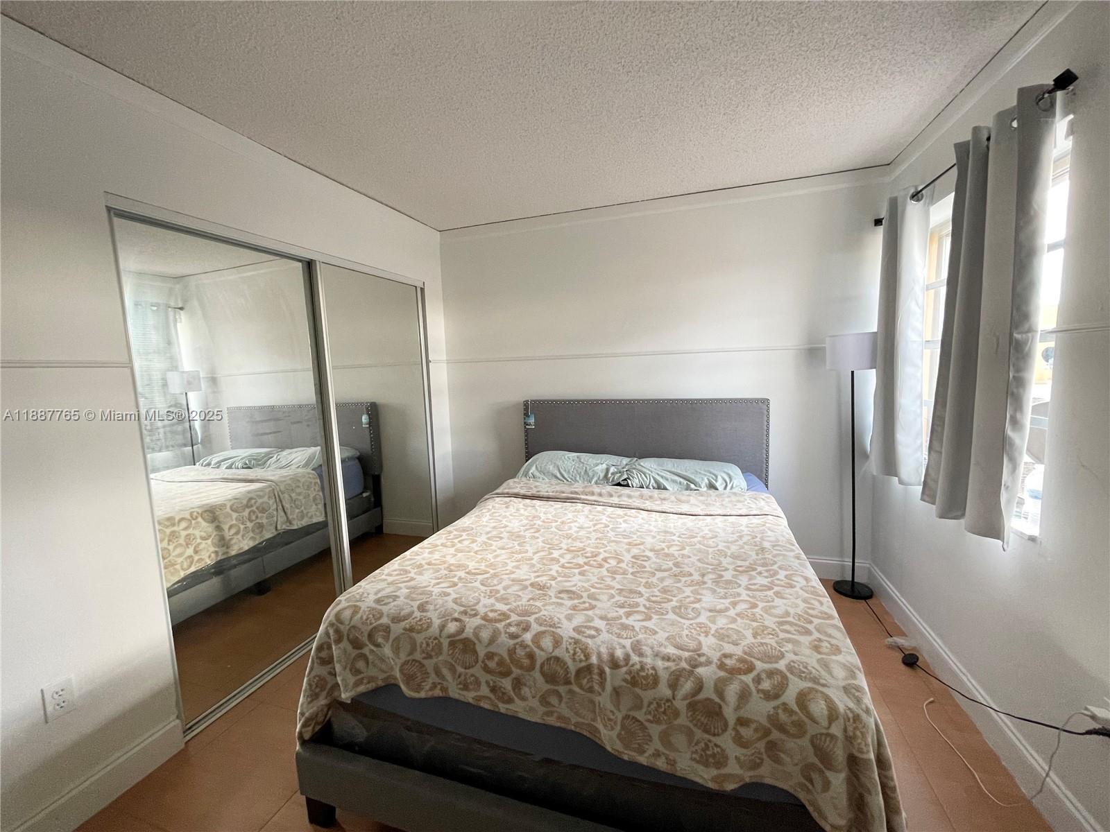 9301 Southwest 4th Street, Unit 224C Miami, FL 33174 - Photo 11 of 19 a bedroom with a bed and a window with glass door