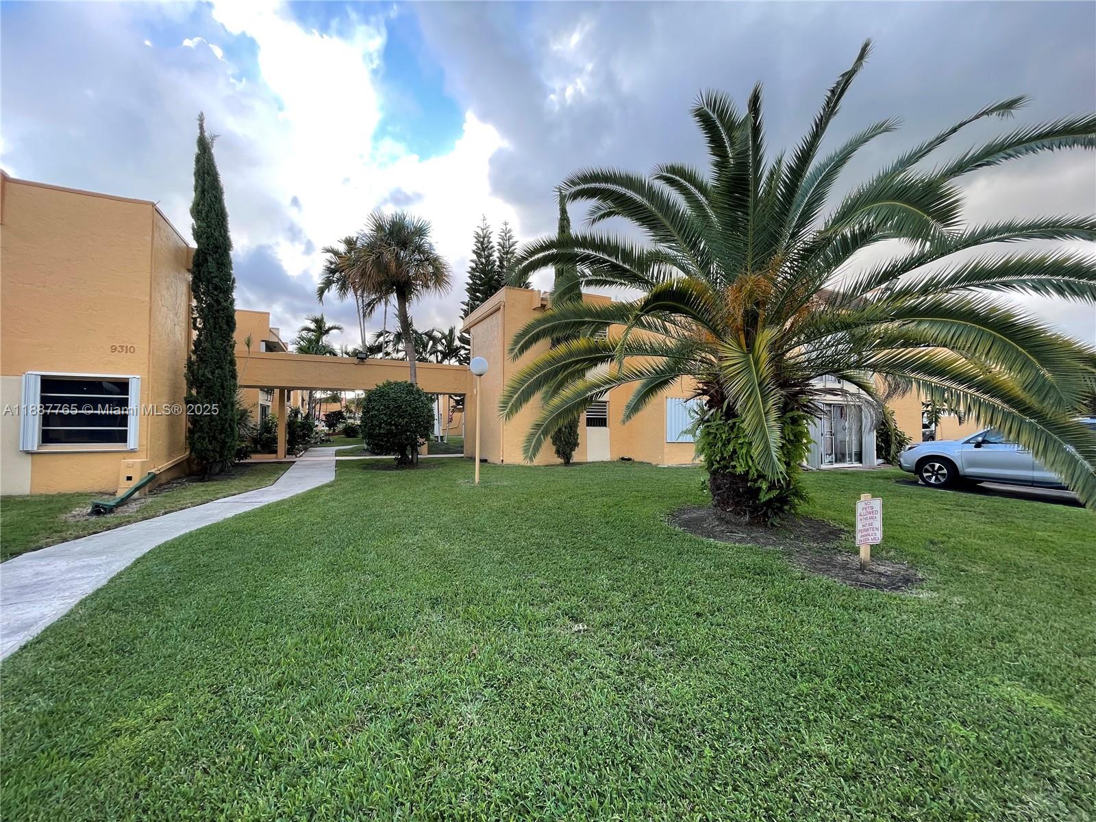 9301 Southwest 4th Street, Unit 224C Miami, FL 33174 - Photo 17 of 19 a palm tree sitting in front of a house with a big yard