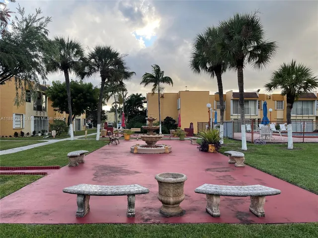a view of a backyard with plants and palm tree