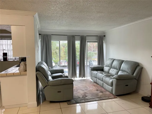 a living room with furniture and floor to ceiling window