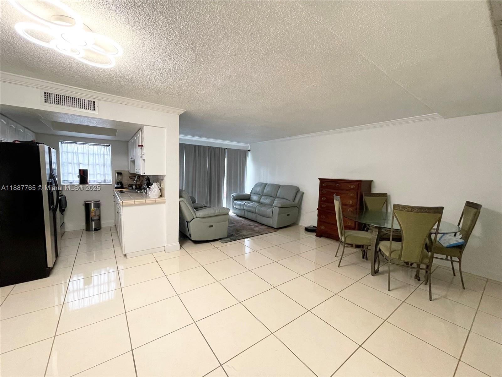 9301 Southwest 4th Street, Unit 224C Miami, FL 33174 - Photo 3 of 19 a kitchen with stainless steel appliances kitchen island granite countertop a refrigerator and a stove top oven