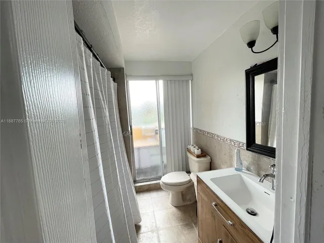 a bathroom with a bathtub sink toilet and mirror