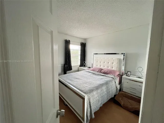 a bed sitting in a bedroom next to a bathroom sink