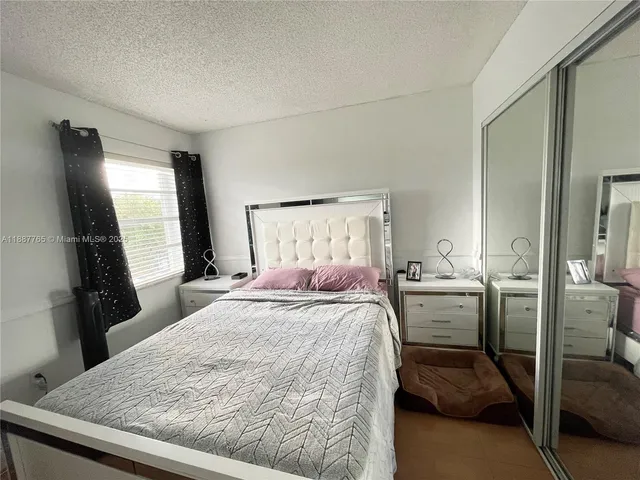 a bedroom with a bed and a flat tv screen on a dresser