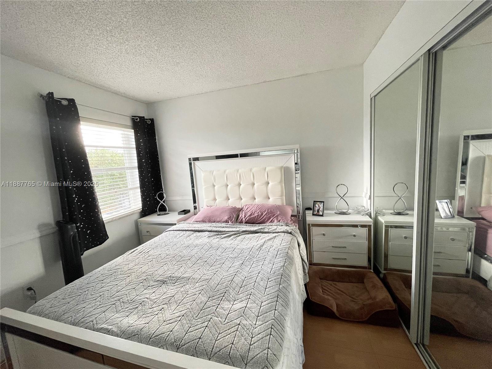 9301 Southwest 4th Street, Unit 224C Miami, FL 33174 - Photo 9 of 19 a bedroom with a bed and a flat tv screen on a dresser