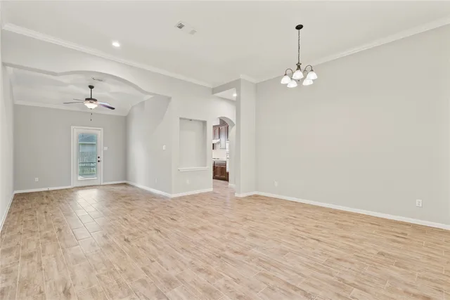 a view of empty room with wooden floor and ceiling fan