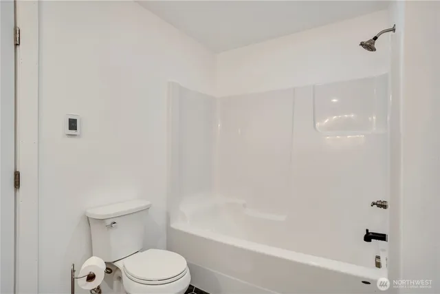 a white toilet sitting next to a bath tub