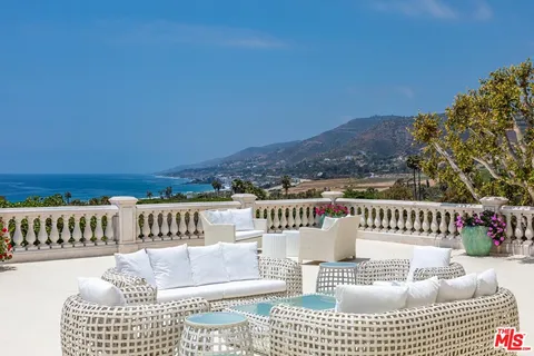 a roof deck with couches and wooden floor