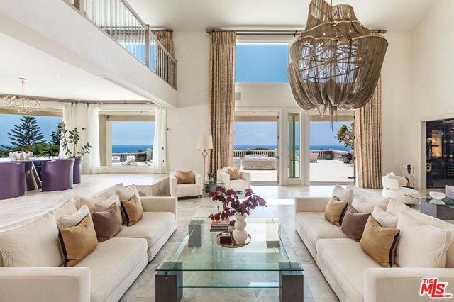 a living room with furniture and a chandelier