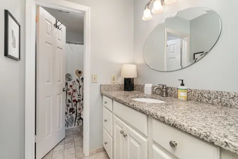 a bathroom with a granite countertop sink and a mirror