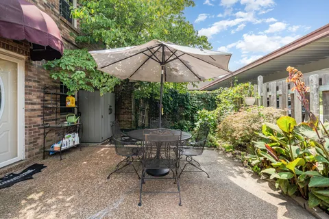 a view of patio with table and chairs under an umbrella