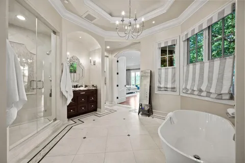 a living room with furniture and a large mirror with wooden floor