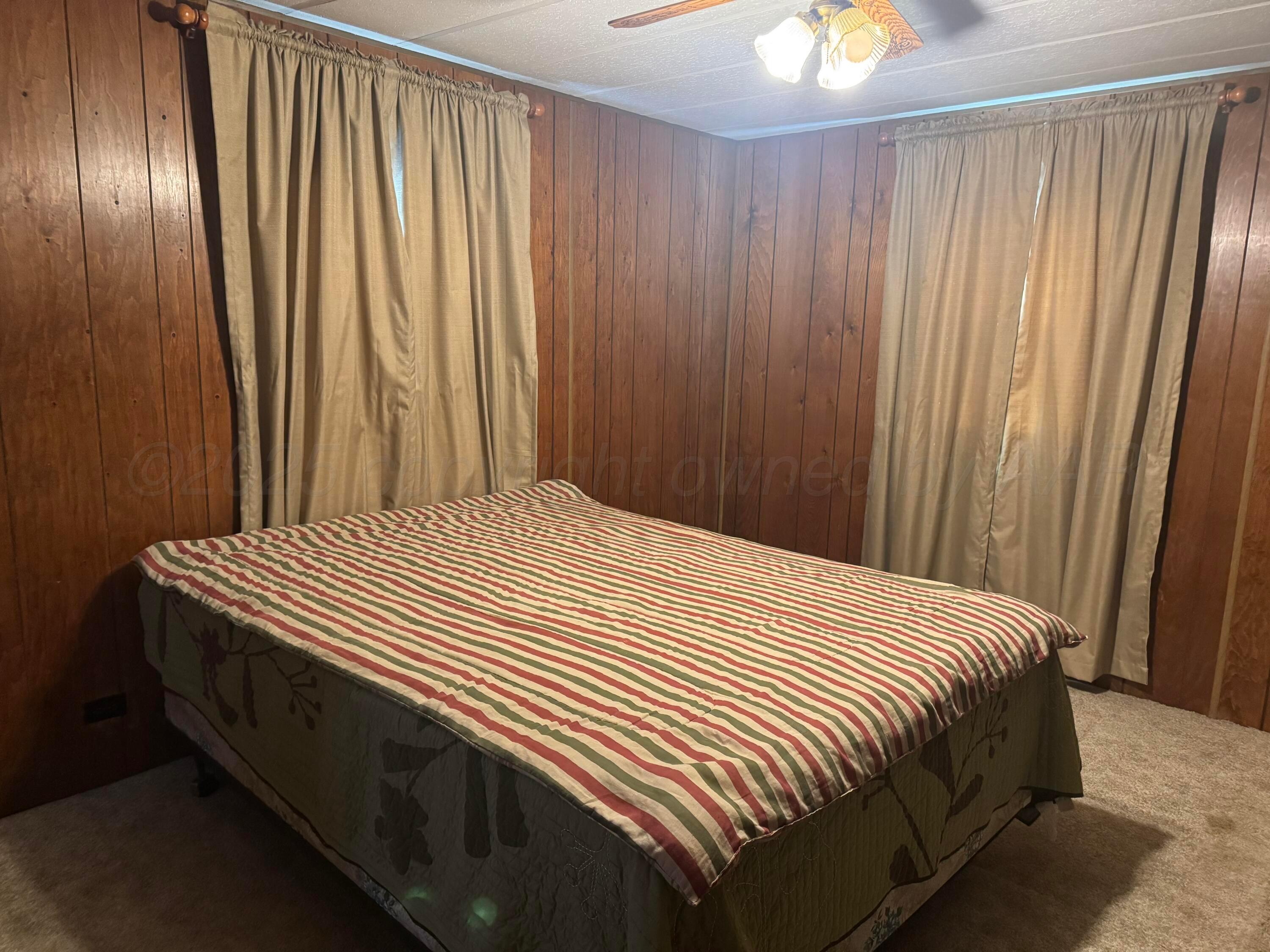 1702 South Baylor Street Perryton, TX 79070 - Photo 22 of 29 a large bed sitting in a bedroom next to a window