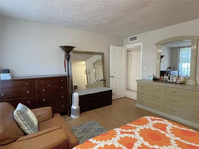 a spacious bedroom with a bed and a dresser