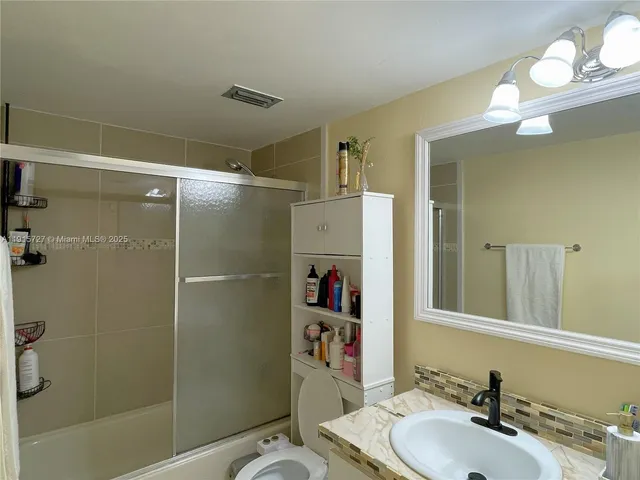 a bathroom with a sink mirror vanity and toilet