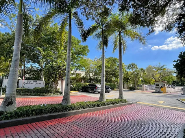 a view of a yard in front of a building with palm trees