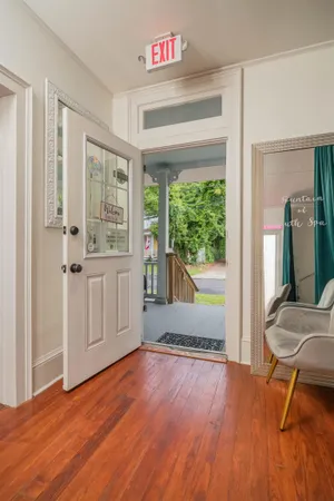 a view of an empty room with glass door and wooden floor