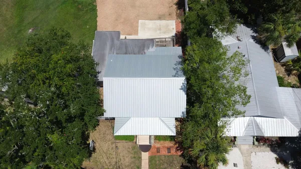 an aerial view of a house with a yard and outdoor seating