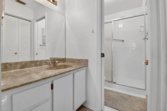 a bathroom with a granite countertop sink and shower