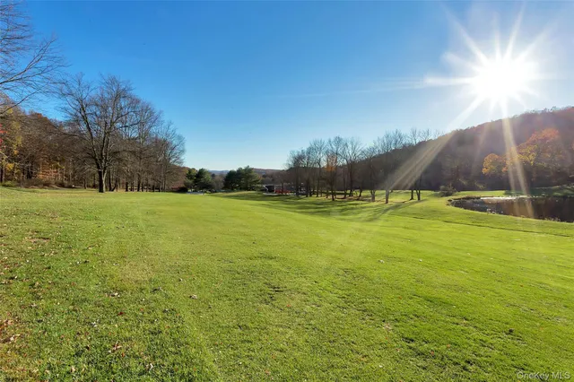 a view of a backyard with swimming pool and sitting area