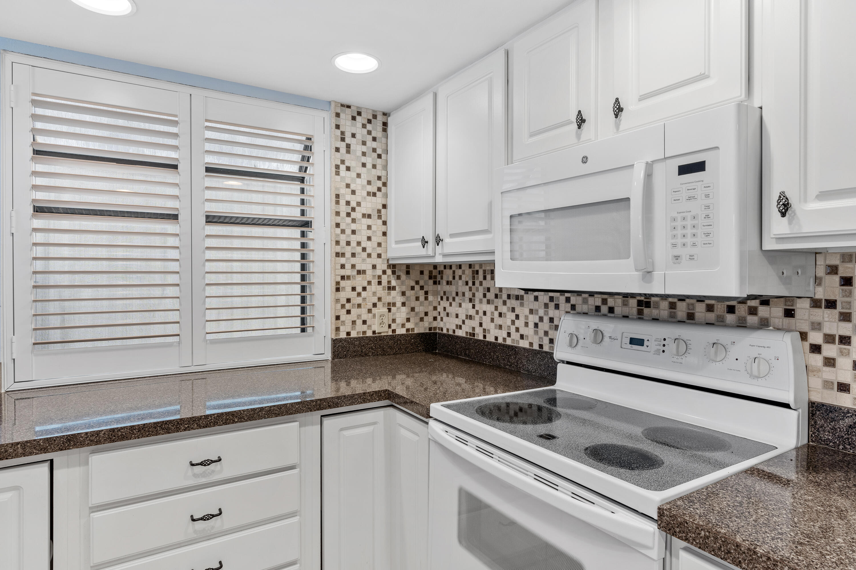 351 L'Atrium Drive Miramar Beach, FL 32550 - Photo 15 of 48 a kitchen with granite countertop white cabinets and white appliances