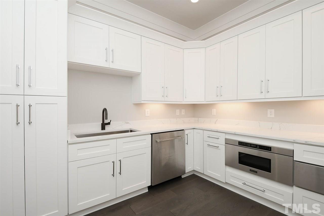 1417 Sky Vista Way Raleigh, NC 27613 - Photo 15 of 26 a kitchen with white cabinets and white appliances