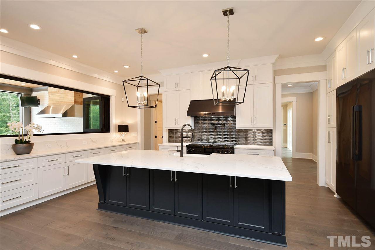 1417 Sky Vista Way Raleigh, NC 27613 - Photo 9 of 26 a kitchen with kitchen island granite countertop a sink a counter top space and stainless steel appliances