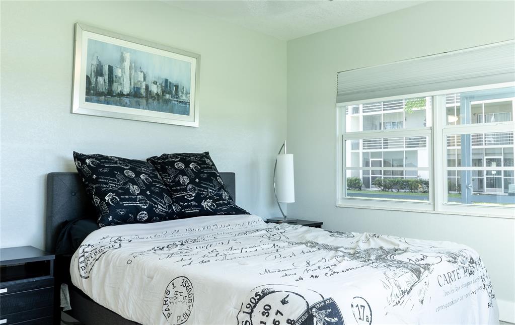 592 Fanshaw O, Unit 592 Boca Raton, FL 33434 - Photo 12 of 25 a bed sitting in a bedroom next to a window with a large bed