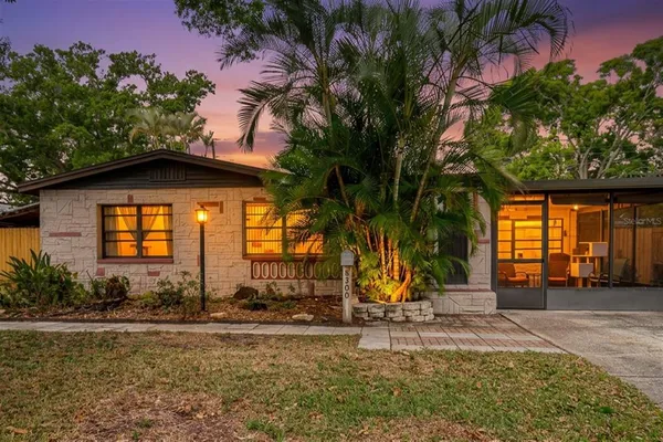 a view of a house with backyard and trees