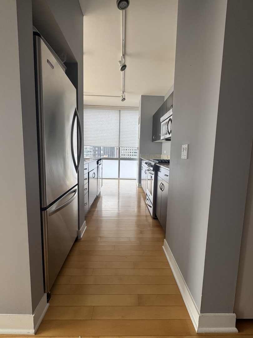 Undisclosed Address Chicago, IL 60601 - Photo 7 of 18 a hallway with wooden floor table and chairs