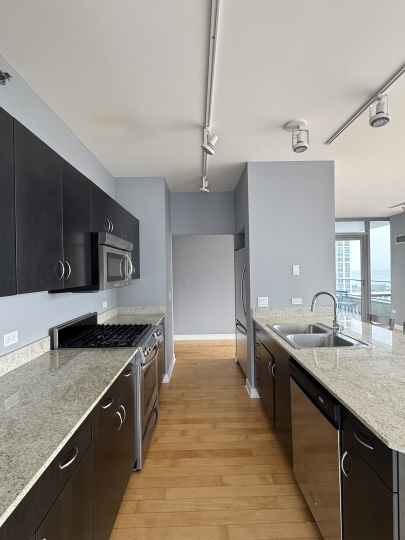 Undisclosed Address Chicago, IL 60601 - Photo 8 of 18 a kitchen with stainless steel appliances granite countertop a sink and stove