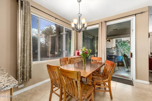 a dining room with furniture a chandelier and wooden floor