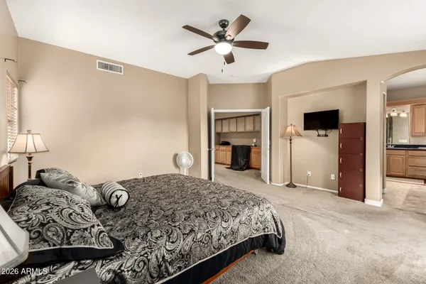 a bedroom with a large bed and a chandelier