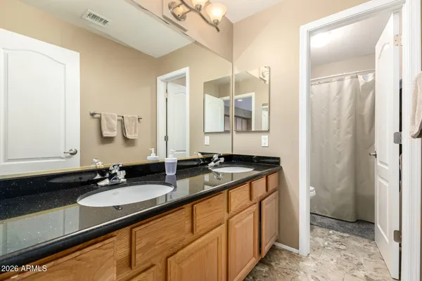 a bathroom with a granite countertop sink and a mirror