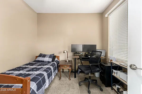 a bedroom with a bed and a computer on a desk