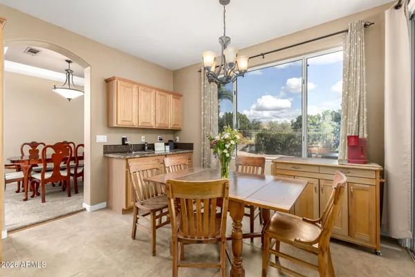 a view of a dining room with furniture a chandelier and a window