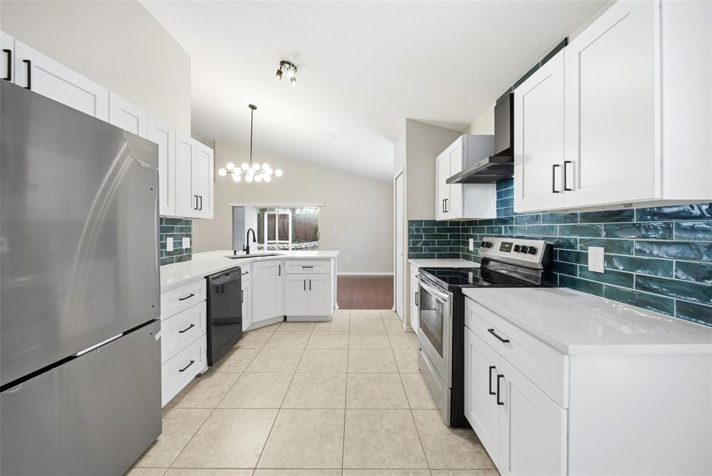 245 Hollinghead Loop Davenport, FL 33896 - Photo 2 of 19 a kitchen with white cabinets and white appliances