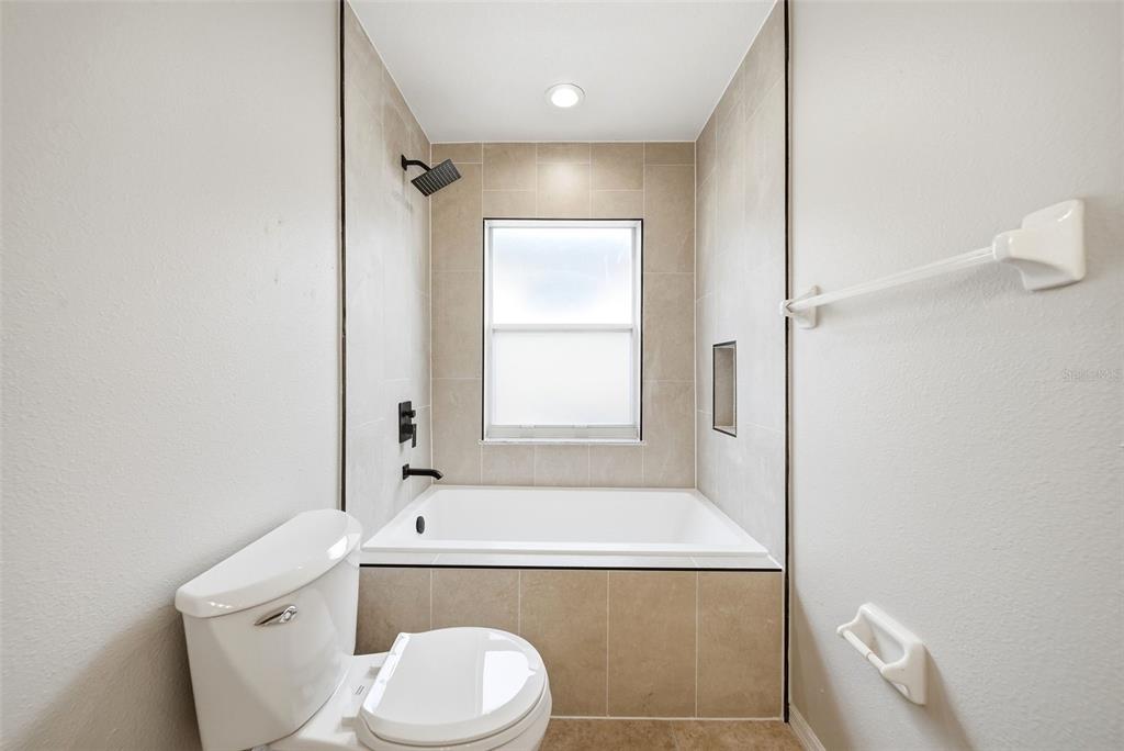 245 Hollinghead Loop Davenport, FL 33896 - Photo 10 of 19 a bathroom with a sink a toilet and shower