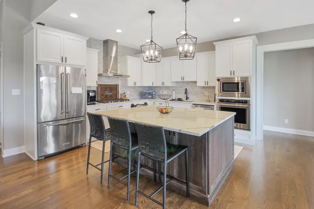a kitchen with a dining table chairs stainless steel appliances and cabinets