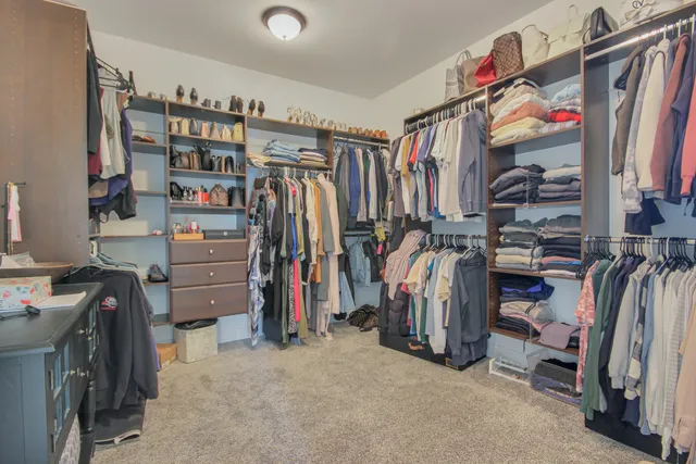 a view of walk in closet with clothes and shoes