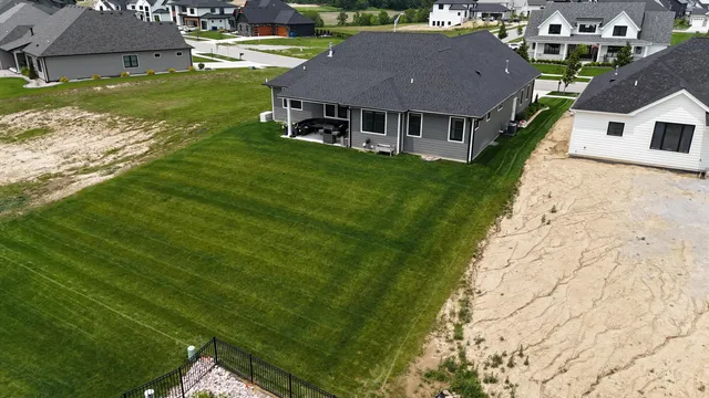 an aerial view of residential houses with outdoor space and trees