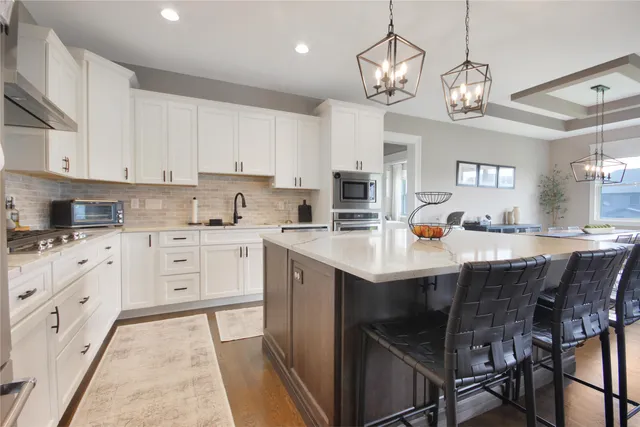 a kitchen with cabinets a center island and appliances