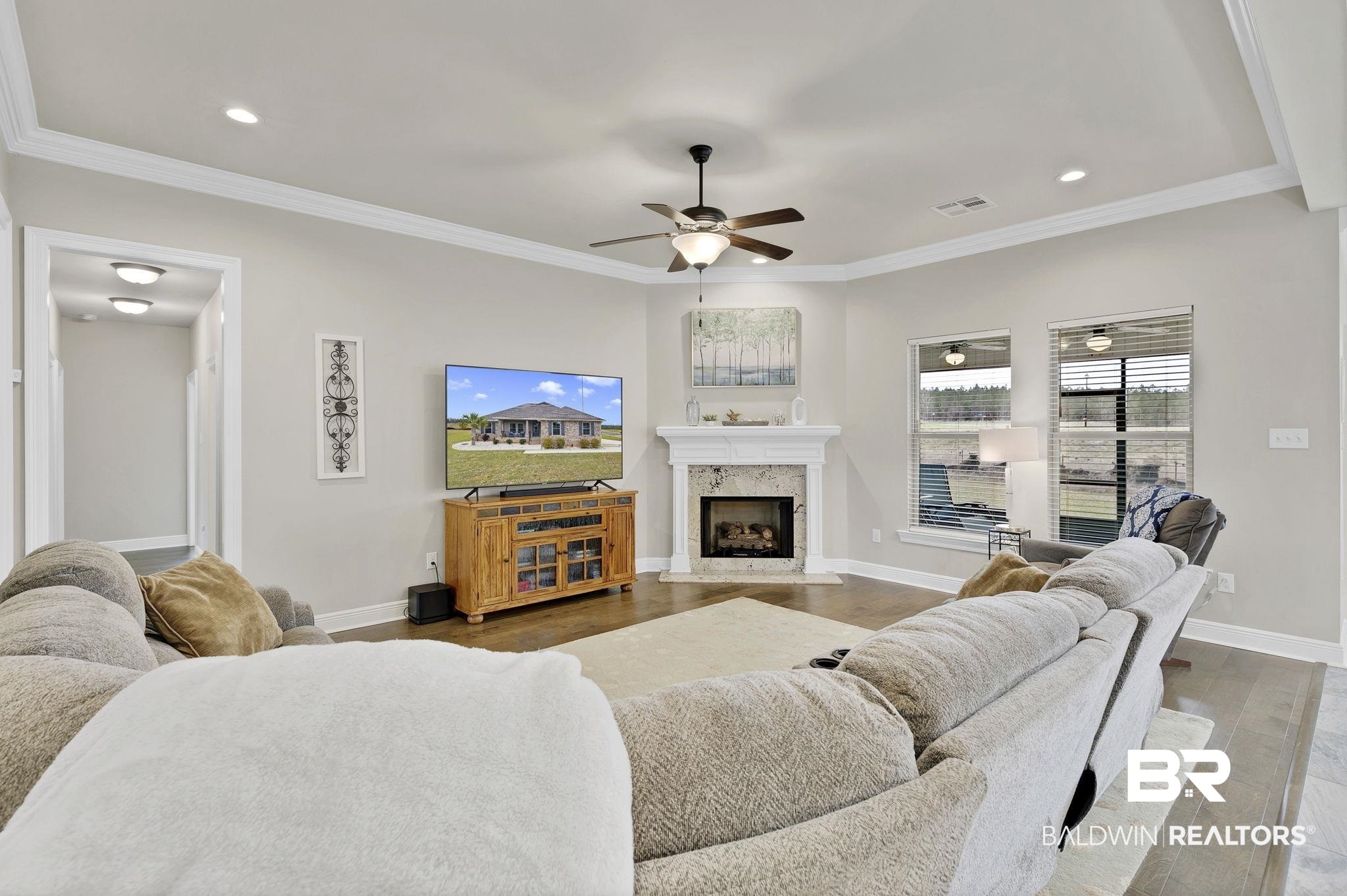 11247 Thistledown Loop Spanish Fort, AL 36527 - Photo 11 of 72 Living area featuring crown molding, visible vents, a fireplace, and wood finished floors