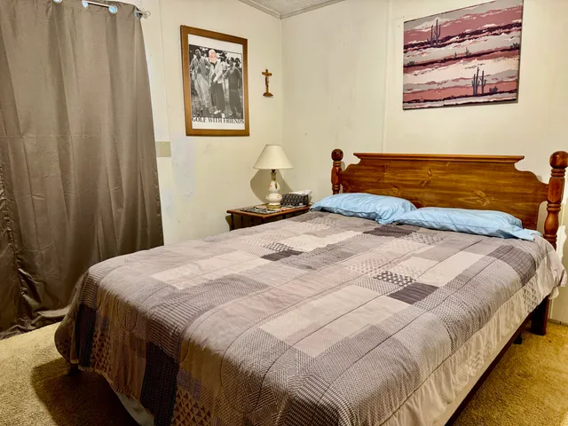 a bedroom with a bed and a painting on the wall