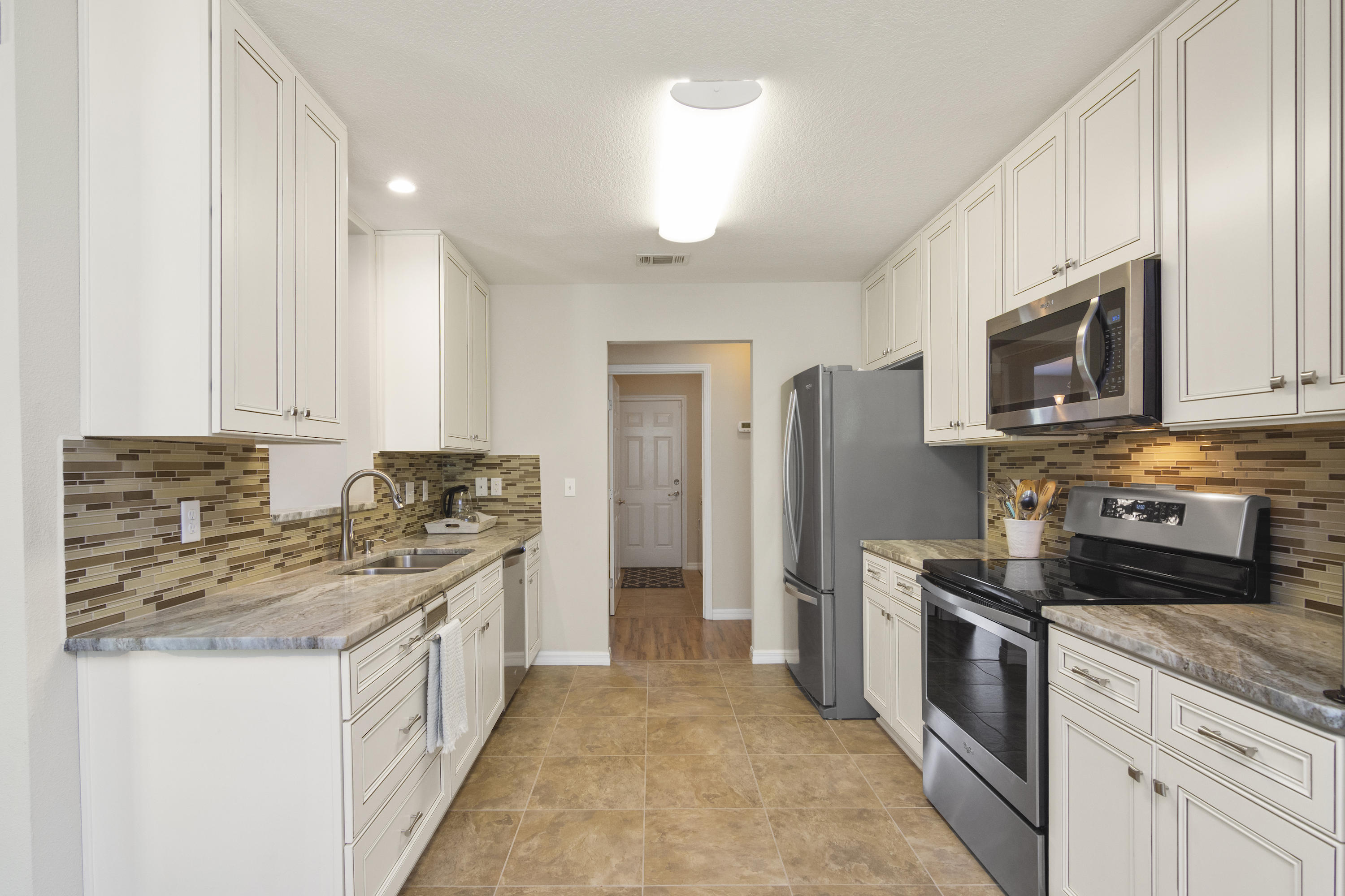 6336 Possum Ridge Road Crestview, FL 32539 - Photo 14 of 40 a kitchen with stainless steel appliances granite countertop a stove a sink and a refrigerator